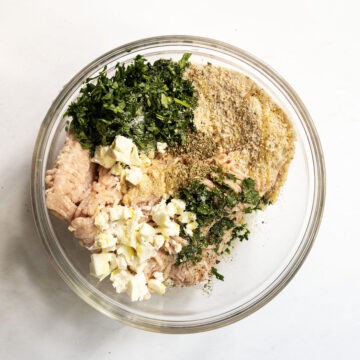 Ground chicken mixed with ingredients to make the chicken burger in a bowl.