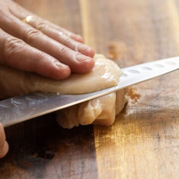 Thinly slicing chicken breast.