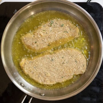 Chicken cutlets frying in oil.
