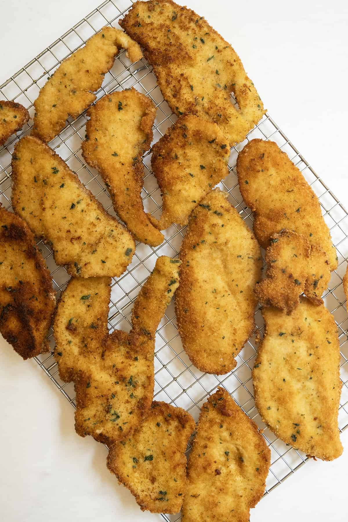 Italian chicken cutlets on a cooling rack.