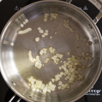 Shallots sauteing in a pan.