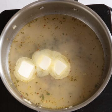 Mussels removed from the pan with butter added to the sauce.