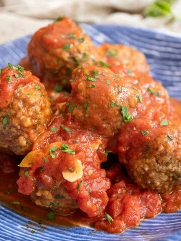 Meatballs covered in tomato sauce in a bowl.