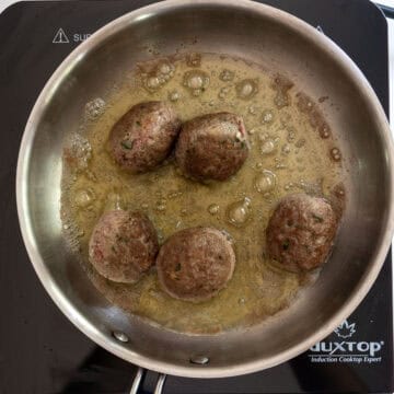 Meatballs browned while frying in a saucepan.