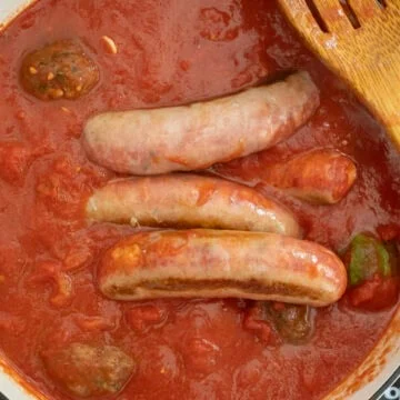 Sauce simmering with sausage and meatballs.