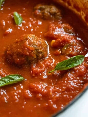 Sunday sauce with meatballs and sausage in a pot.