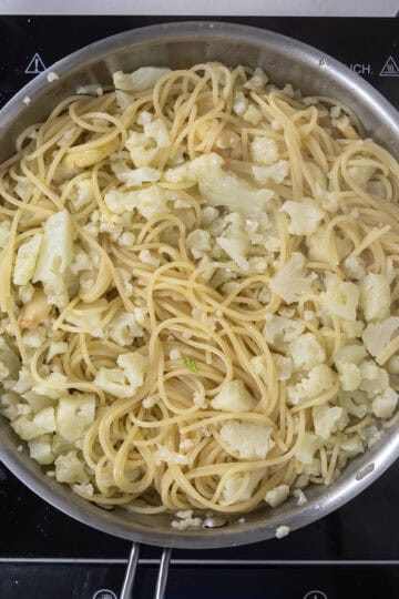 spaghetti added to pan with cauliflower and garlic.