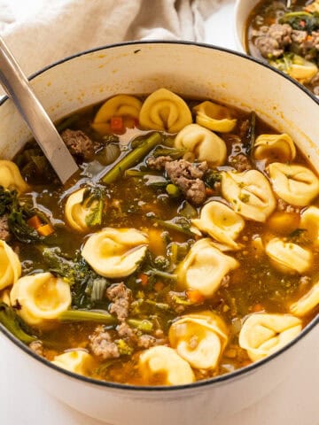 Sausage and broccoli rabe soup with tortellini in a dutch oven.