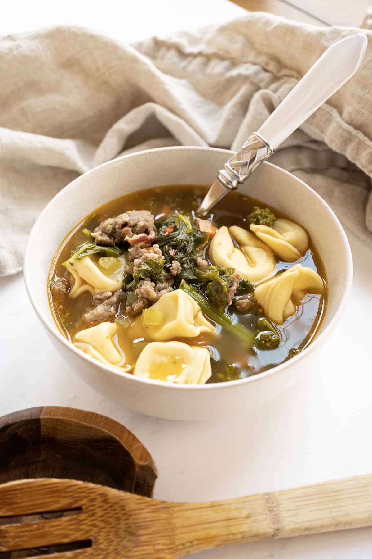 Sausage and broccoli rabe soup with tortellini in a dutch oven.