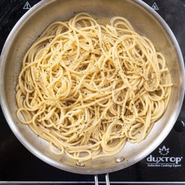 Pasta added to the saucepan with black pepper.