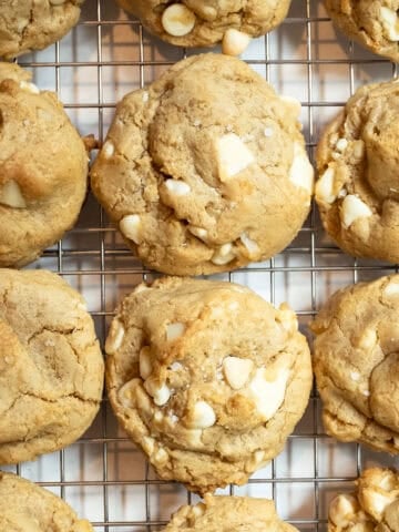 White chocolate macadamia nut cookies on a cooling rack.