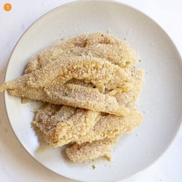 Breaded chicken tenderloins on a plate.