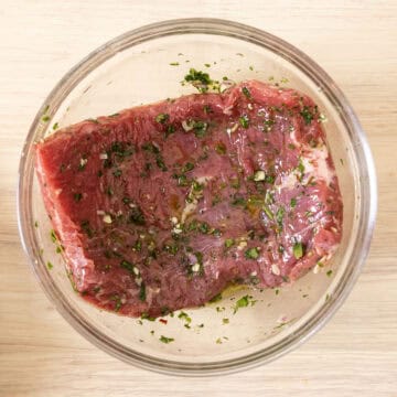 Marinating steak in chimichurri.