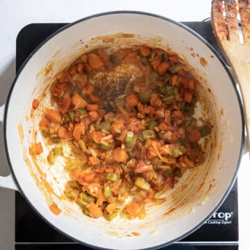 Tomato paste mixed with sauteing vegetables to caramelize.
