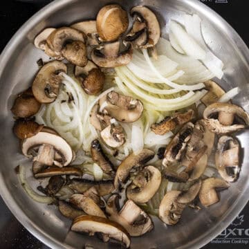 Sauteing mushrooms and onions in a saucepan.