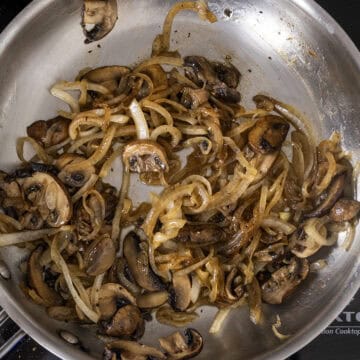 Caramelized mushrooms and onions in a pan.