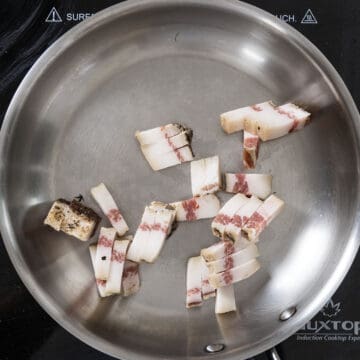 Guanciale in a cold pan about to fry.