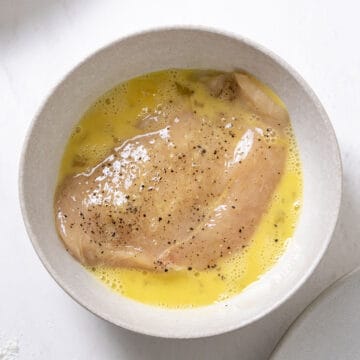 Chicken breast in egg wash.