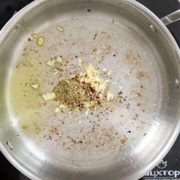 Sauteing garlic and seasonings in a saucepan.