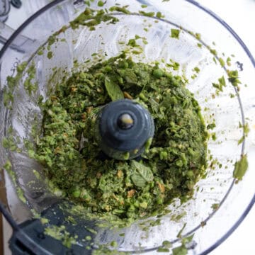 Basil, garlic, salt, and peas combined in food processor.