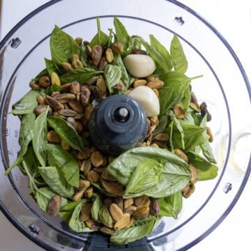 Ingredients for pesto in a food processor.