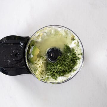 cilantro, garlic, and lime juice added to the food processor.