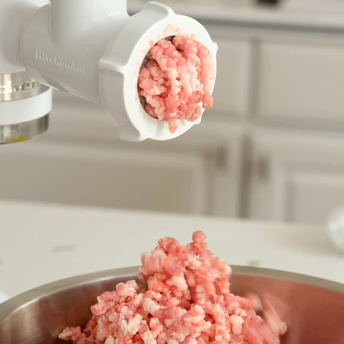 Grinding pork in a meat grinder.
