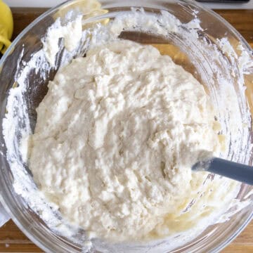 Dry ingredients mixed into the wet ingredients in a bowl with butter.
