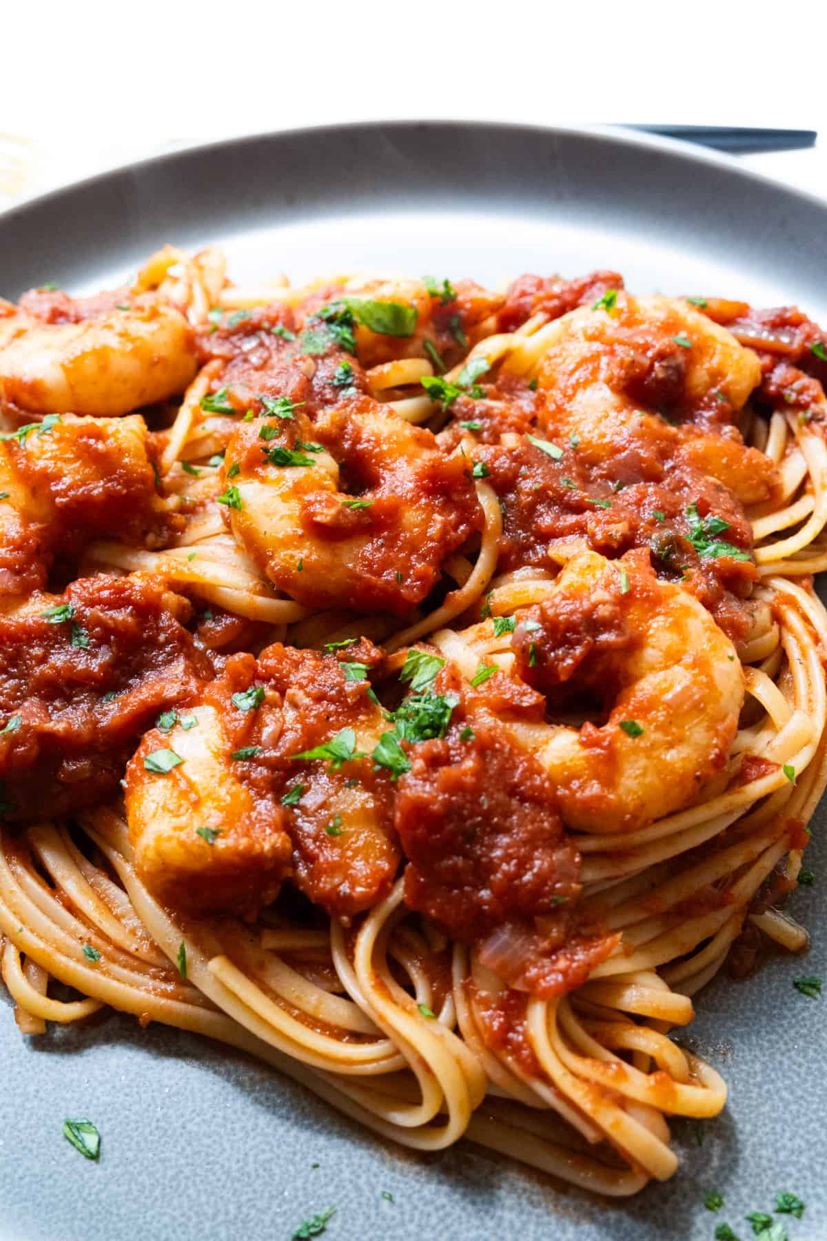 Shrimp fra diavolo with linguine on a plate.