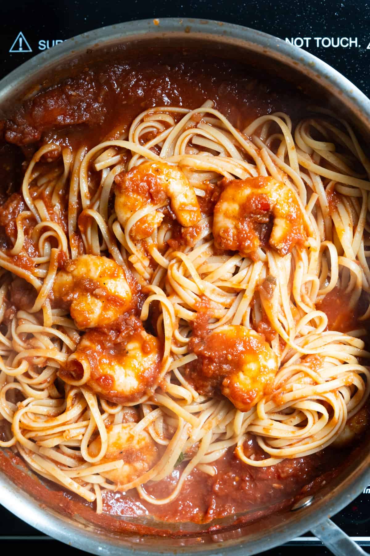 Linguine combined with sauce and shrimp.