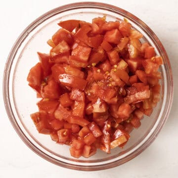Chopped tomatoes, drained, in a bowl.