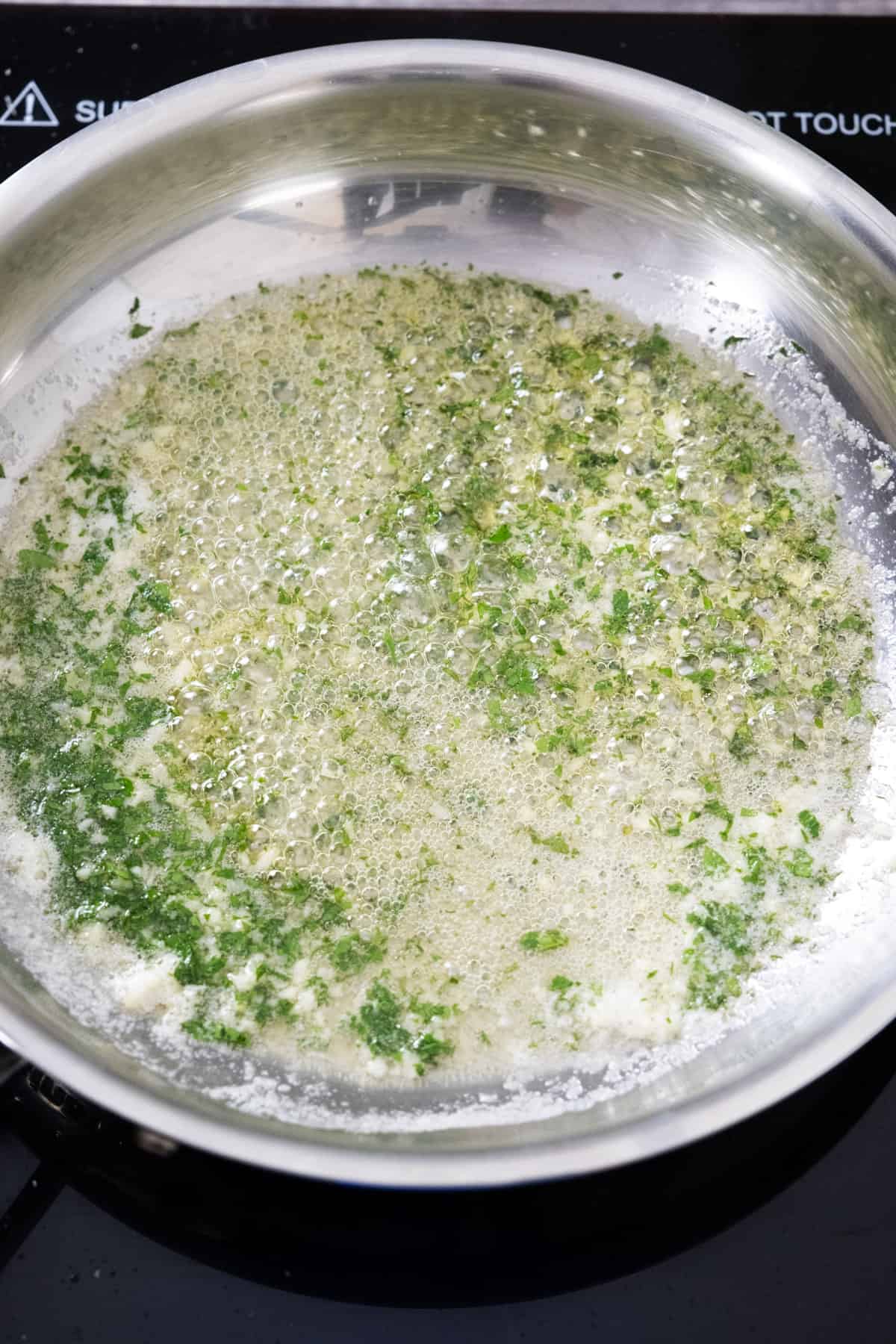 garlic butter sauce with parsley simmering on low heat
