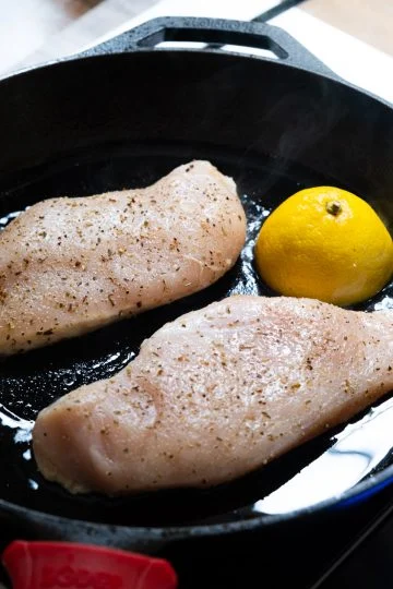 Raw chicken in cast iron with lemon.