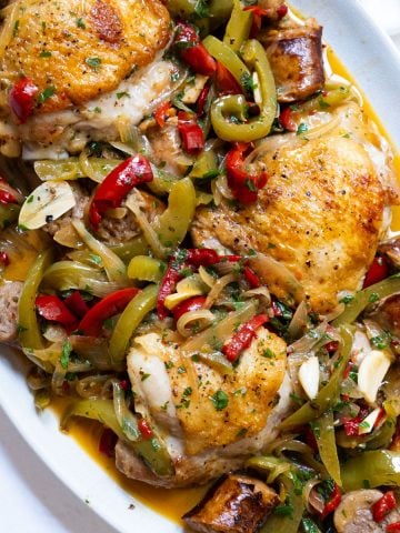 chicken scarpariello sitting on a plate with its braised juices