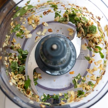 Basil, almonds, and garlic processed in food processor.