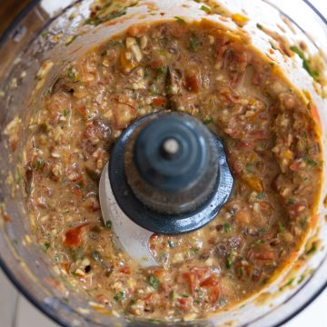 Cherry tomatoes and olive oil added to the pesto in food processor.