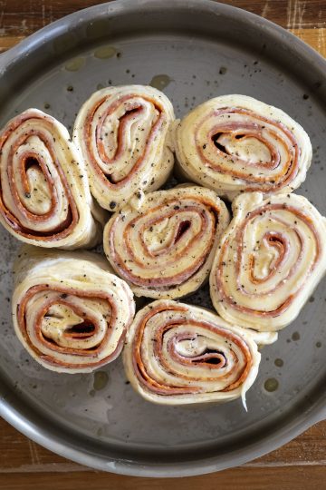 dough cut into equal length rolls and placed on their sides in a cake pan. Leaving about an inch or two on the sides.