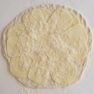 dough topped with mozzarella, provolone, and parmesan