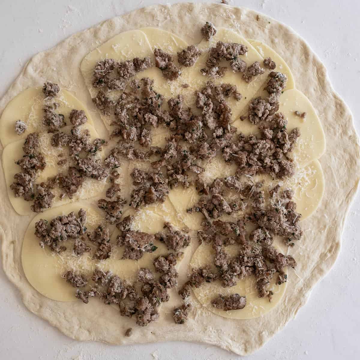 dough topped with ground sausage
