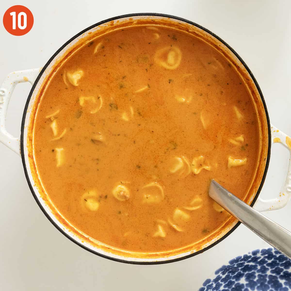 Stirring heavy cream into the soup.
