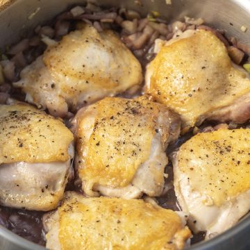 Chicken thighs braising in red wine and fennel sauce