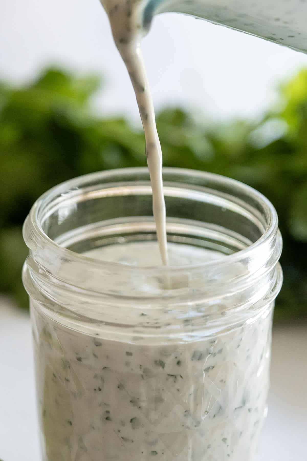 pouring cilantro lime ranch in a mason jar