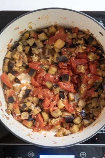whole plum tomatoes added to eggplant