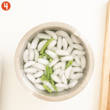 Cooked green beans in an ice bath.