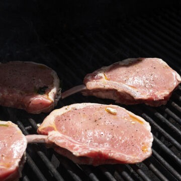 Seasoned pork chops placed on the grill.