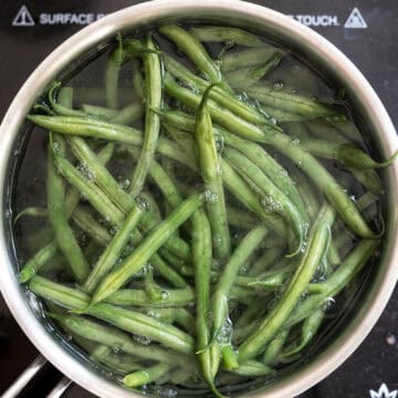 Green beans boiling in a pot of water.