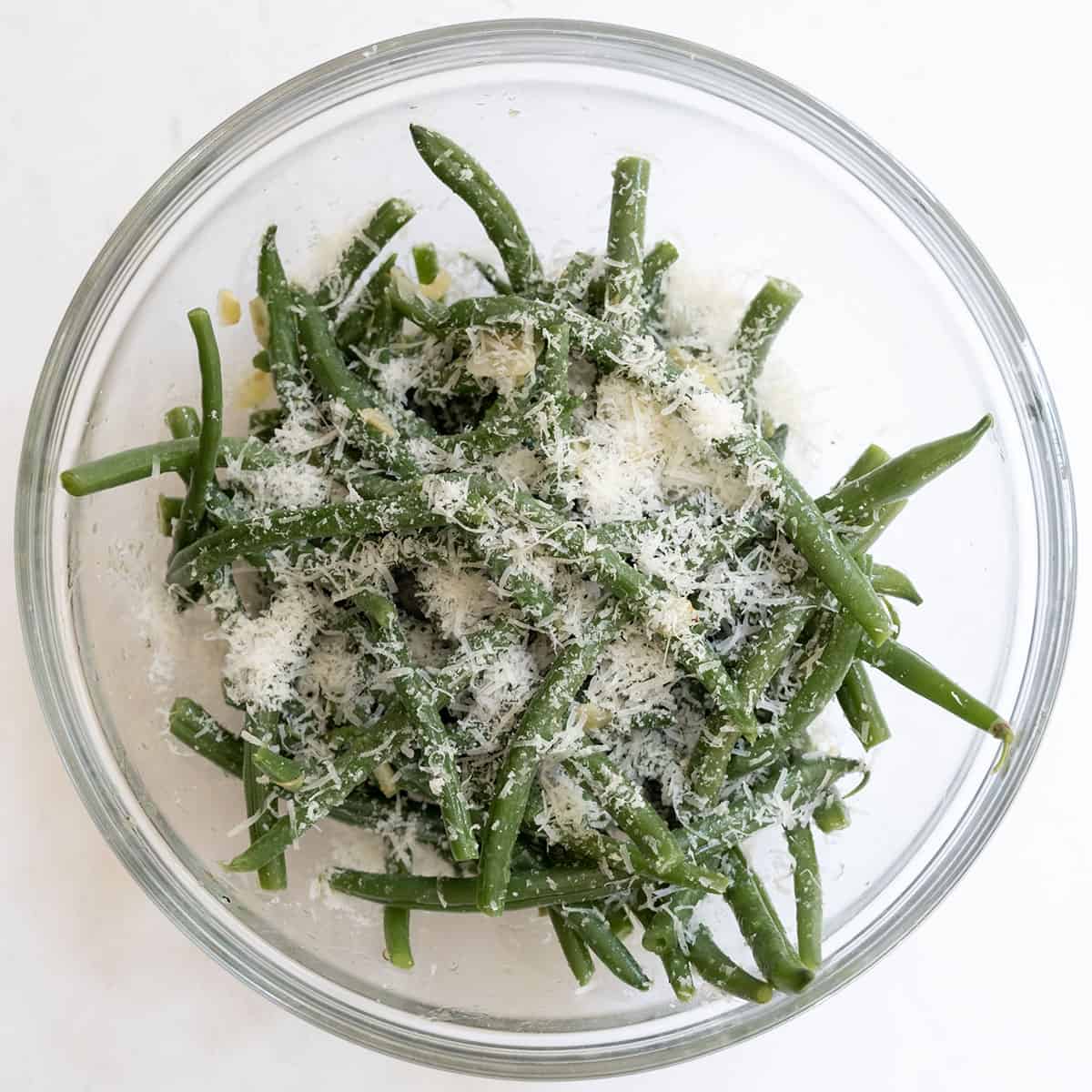 Green beans tossed parmesan in a bowl.