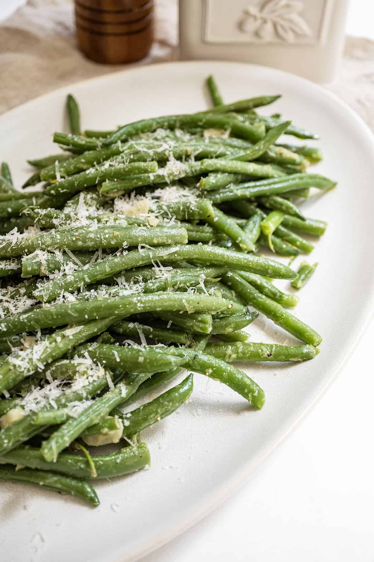 Green beans sprinkled with parmesan on a plate.