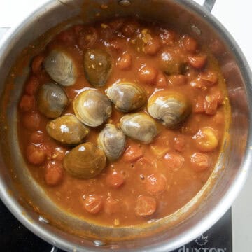 Closed clams simmering in the sauce.