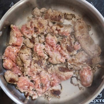 Searing sausage in a pan.